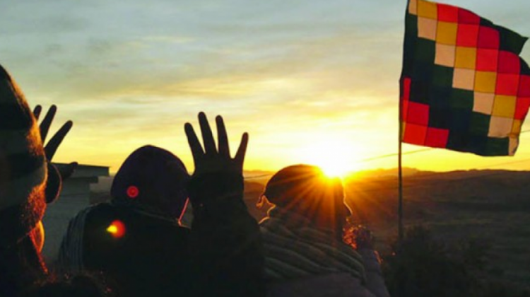 Personas levantan las manos para recibir los primeros rayos de sol del 21 de junio.
