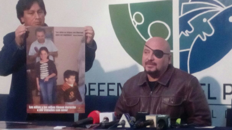 El Defensor del Pueblo y uno de sus colaboradores muestran el afiche en defensa de la niñez. Foto: ANF