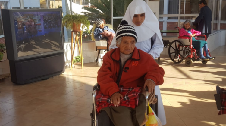 Una religiosa traslada a una anciana en el Hogar San Ramón. Foto: ANF