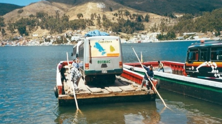 Buses y otros vehículos pasan el estrecho de Tiquina en barcazas de madera. Foto: Internet.