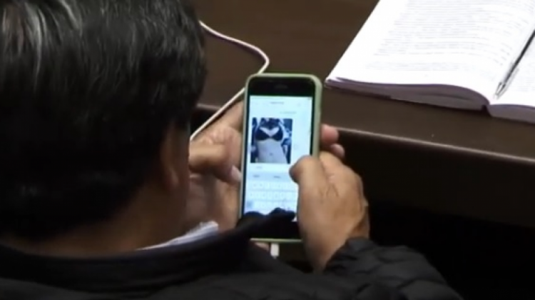 El diputado de espaldas con su teléfono. Foto: Captura video Gigavisión