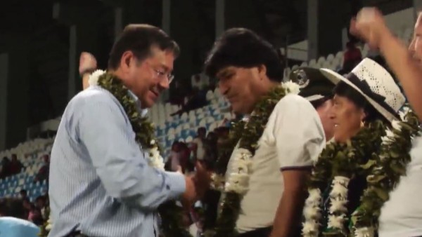 Luis Arce y Evo Morales ese dan la mano, aunque no se miran de frente. Foto: Captura de video.