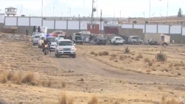 Salida de Camacho en una ambulancia rodeada por varios vehículos y motocicletas de la Policía. Foto: Captura Unitel