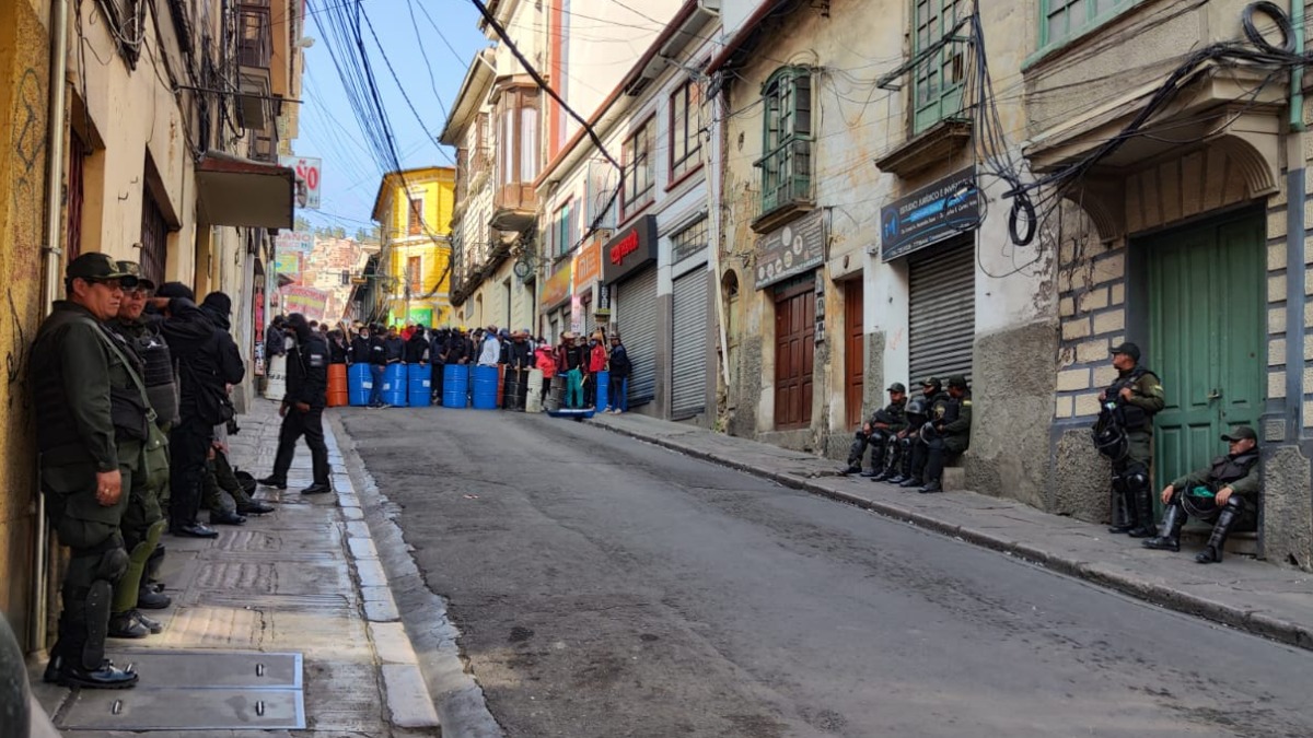 Los policías replegados hacia las paredes y civiles con escudos al fondo. Foto: ANF