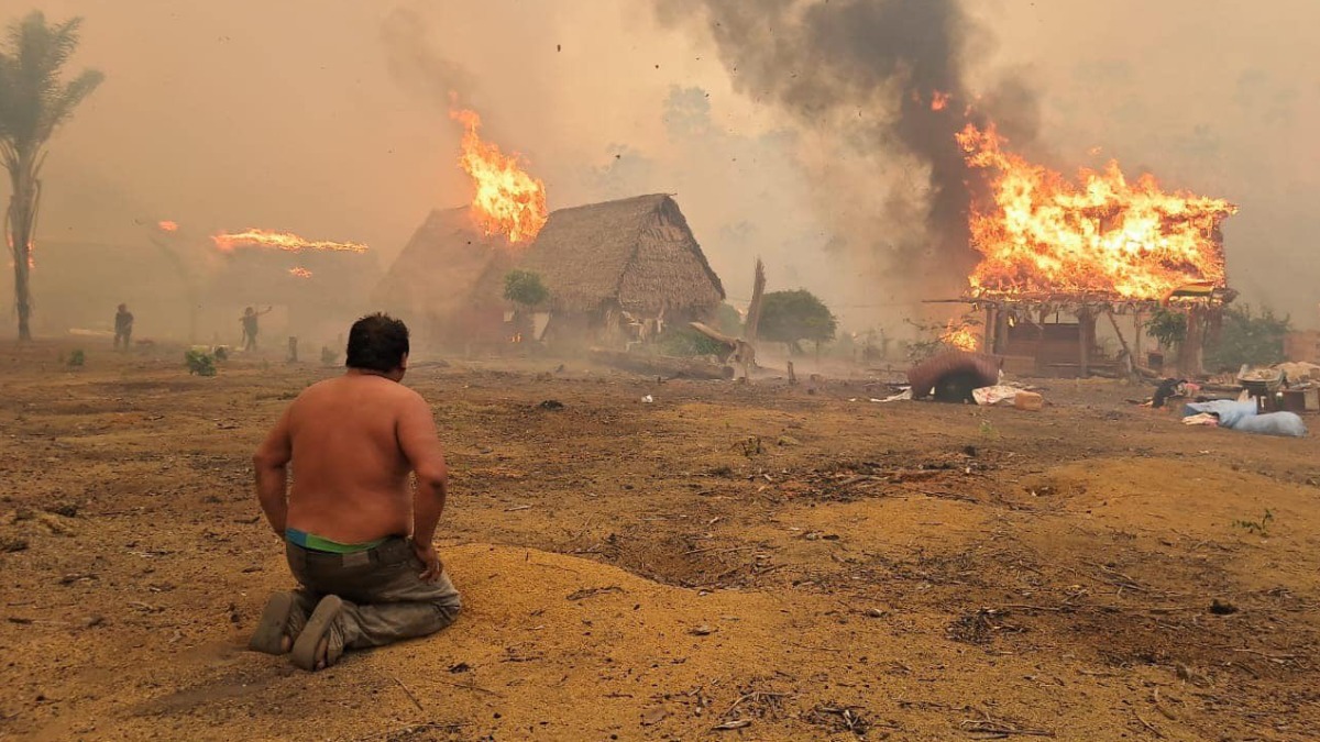 Un comunario resignado ve cómo el fuego consume su vivienda. Foto: Alex Vaca